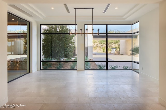 spare room with a raised ceiling and a wealth of natural light