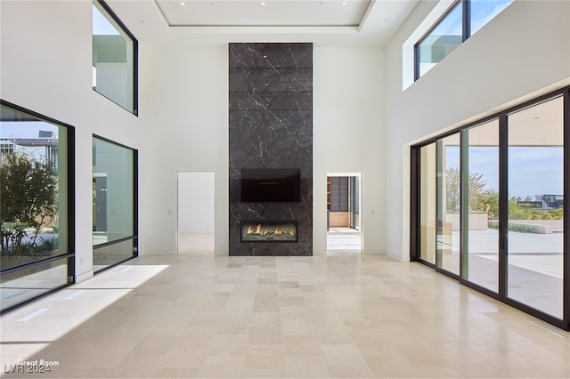 unfurnished living room featuring a fireplace and a towering ceiling