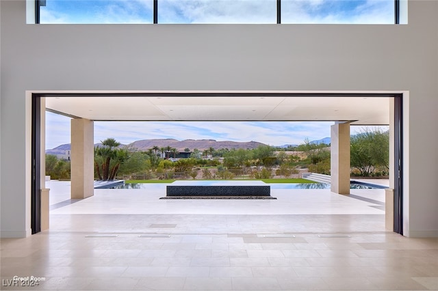 doorway featuring a mountain view, a healthy amount of sunlight, and a high ceiling