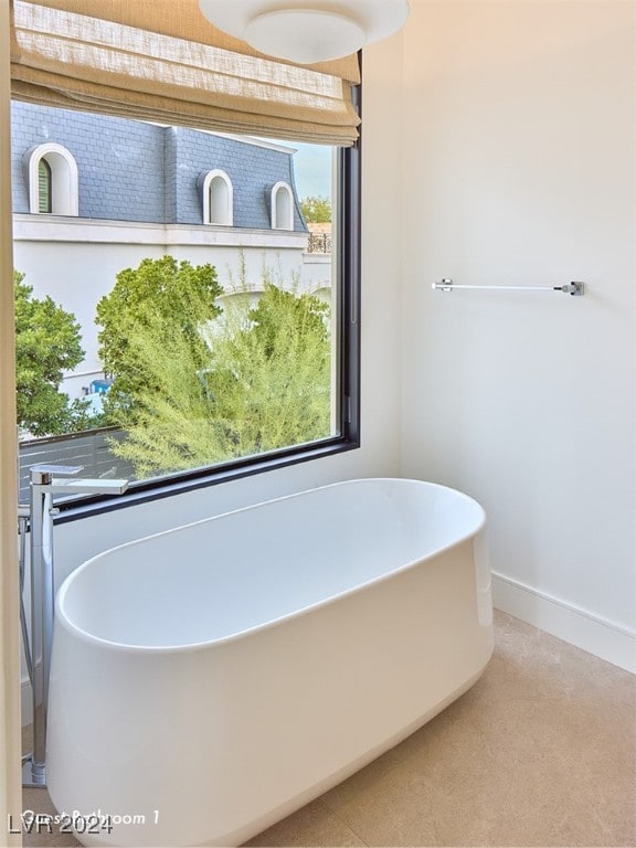 bathroom with a healthy amount of sunlight and a bath