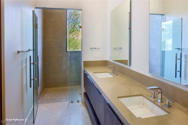 bathroom featuring tile patterned flooring, vanity, and tiled shower