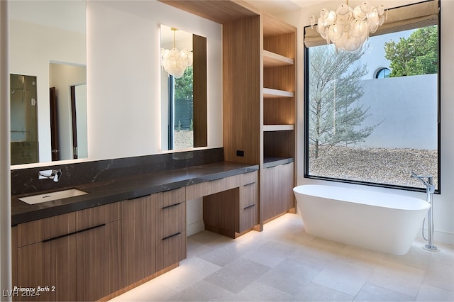 bathroom featuring vanity, a bath, and an inviting chandelier