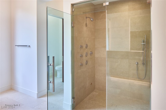 bathroom with toilet and a tile shower