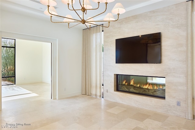 unfurnished living room with a large fireplace and a chandelier