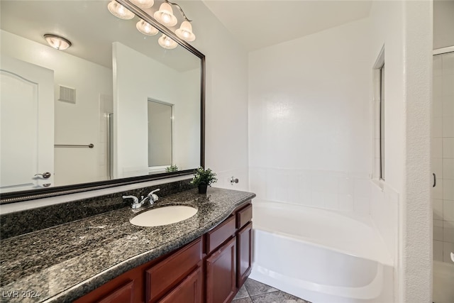 bathroom with tile patterned floors, a washtub, and vanity