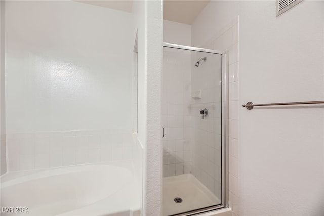 bathroom featuring shower with separate bathtub