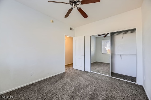 unfurnished bedroom with ceiling fan, dark carpet, and a closet