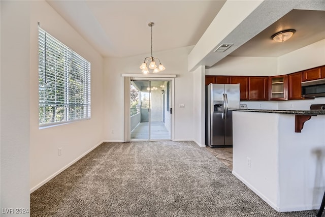 kitchen with light carpet, an inviting chandelier, a kitchen breakfast bar, hanging light fixtures, and appliances with stainless steel finishes