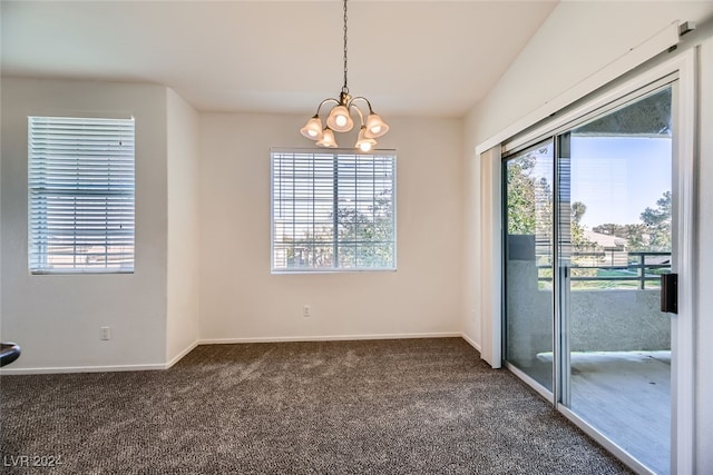 empty room featuring dark carpet and a notable chandelier