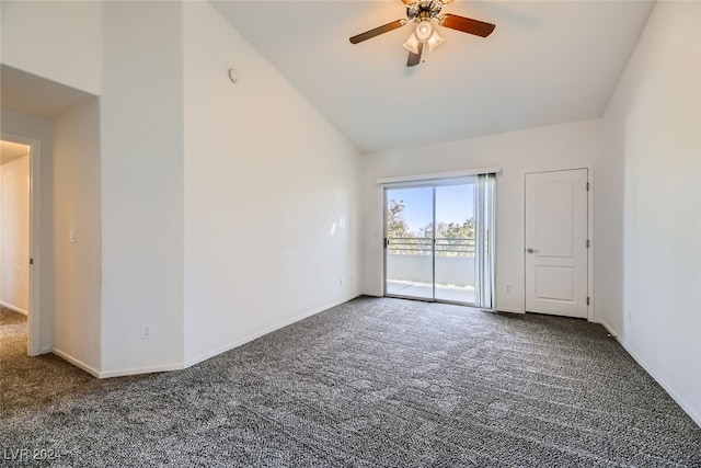 empty room featuring ceiling fan, dark carpet, and vaulted ceiling