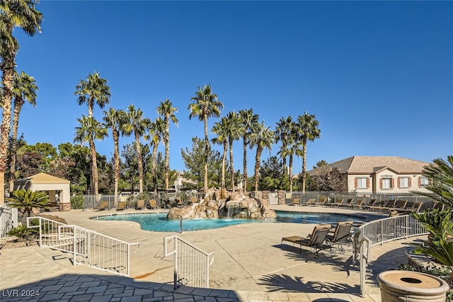 view of swimming pool with pool water feature and a patio area