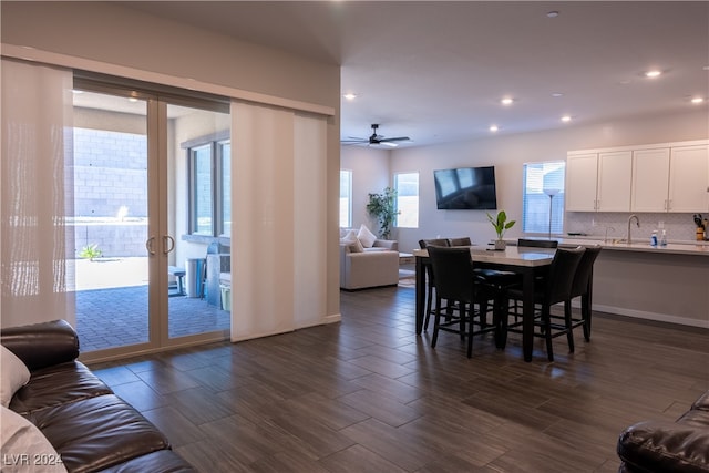 dining space featuring plenty of natural light, ceiling fan, sink, and dark wood-type flooring