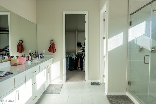 bathroom featuring tile patterned flooring, vanity, and walk in shower