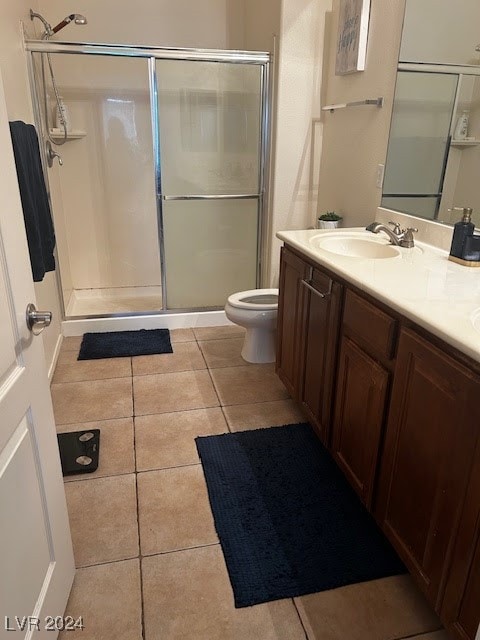 bathroom with toilet, vanity, tile patterned floors, and an enclosed shower