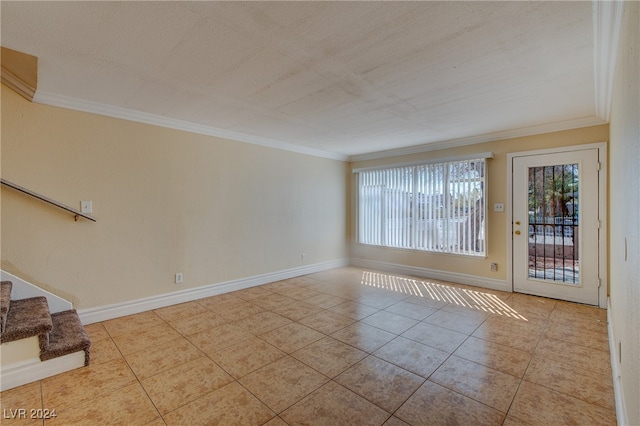 spare room featuring crown molding and light tile patterned floors