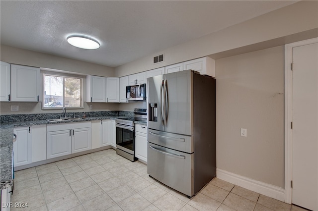 kitchen featuring sink, white cabinets, a textured ceiling, and appliances with stainless steel finishes