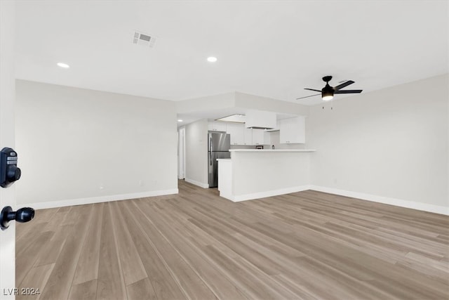 unfurnished living room featuring ceiling fan and light hardwood / wood-style floors