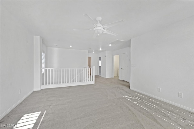 empty room with ceiling fan and light carpet