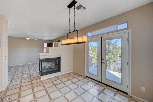 interior space featuring a multi sided fireplace, french doors, and ceiling fan