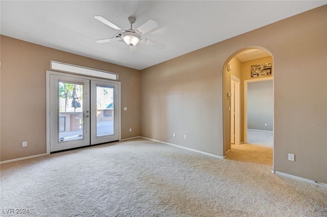 unfurnished room with ceiling fan, french doors, and light colored carpet