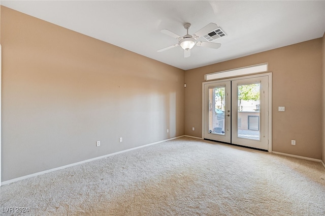 carpeted spare room featuring french doors and ceiling fan