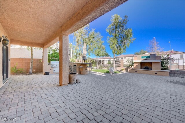 view of patio featuring area for grilling and an outdoor fireplace