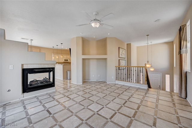 unfurnished living room with ceiling fan, a multi sided fireplace, and built in shelves