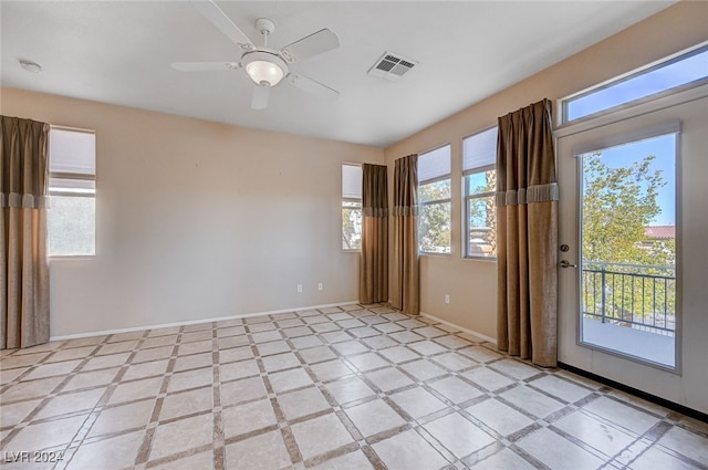 spare room featuring ceiling fan and a healthy amount of sunlight