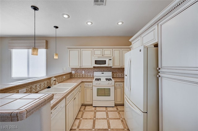 kitchen with pendant lighting, white appliances, backsplash, sink, and kitchen peninsula