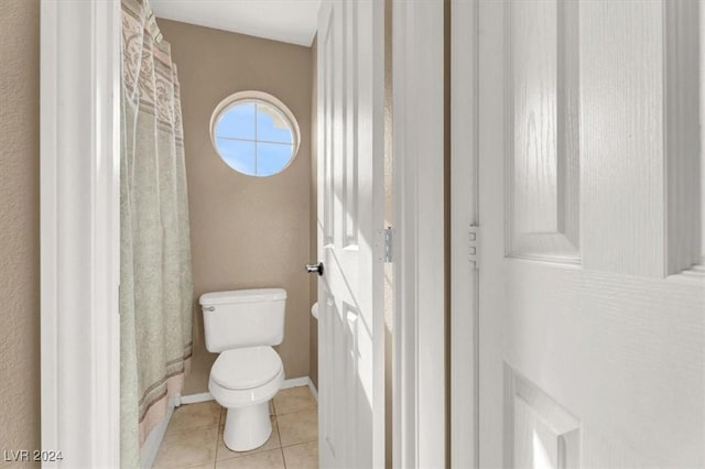 bathroom with baseboards, toilet, and tile patterned floors