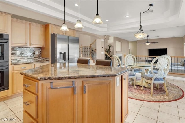 kitchen featuring light tile patterned flooring, a kitchen island, stainless steel fridge with ice dispenser, light brown cabinetry, and a tray ceiling