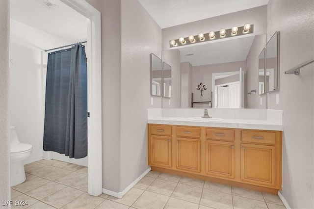 full bathroom featuring tile patterned flooring, vanity, toilet, and baseboards