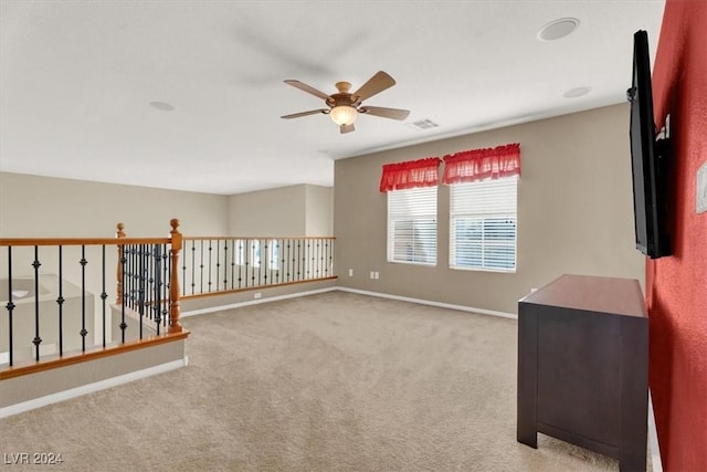 carpeted empty room featuring a ceiling fan, visible vents, and baseboards