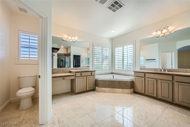 bathroom featuring tiled bath, vanity, a chandelier, and toilet