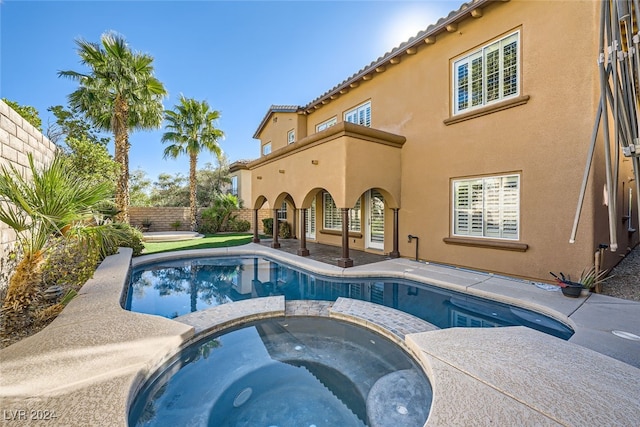 view of pool with an in ground hot tub and a patio