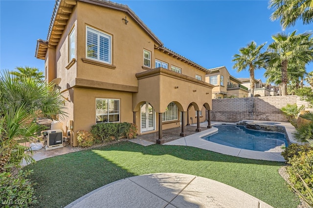 back of property featuring a fenced in pool, a patio area, a yard, and a balcony