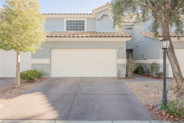 mediterranean / spanish-style house with a garage