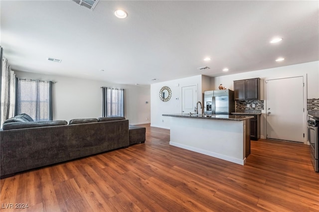 kitchen with sink, a center island with sink, dark wood-type flooring, and appliances with stainless steel finishes