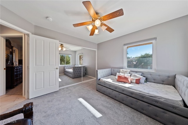 carpeted living room featuring ceiling fan