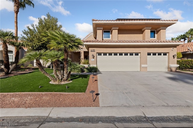 mediterranean / spanish house with a garage and a front lawn