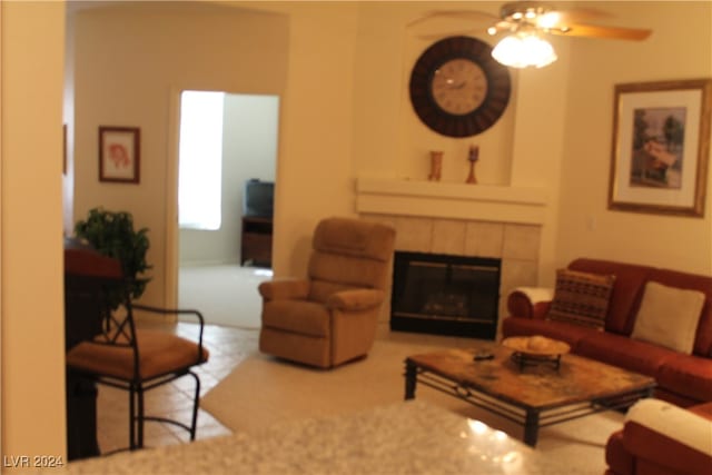 living room with ceiling fan and a fireplace