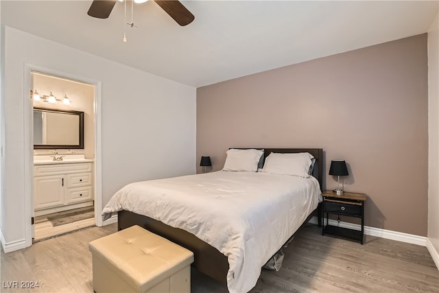 bedroom with hardwood / wood-style floors, ceiling fan, and ensuite bath