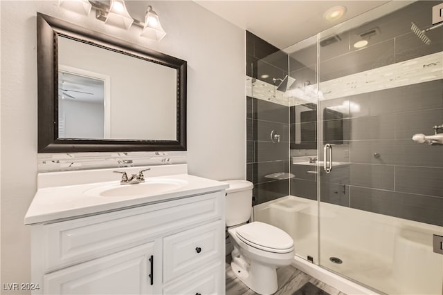 bathroom featuring vanity, toilet, and an enclosed shower