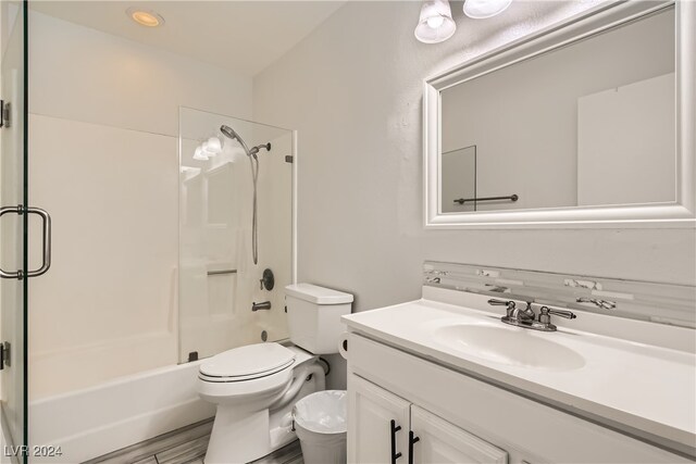 full bathroom with hardwood / wood-style floors, vanity, toilet, and bath / shower combo with glass door