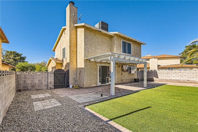 rear view of house featuring a pergola, a patio area, and a lawn