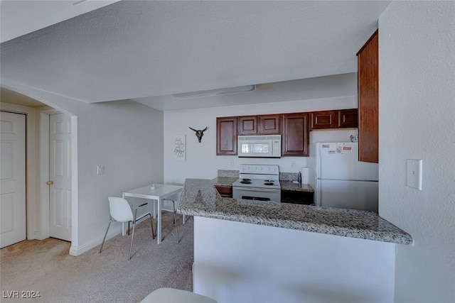 kitchen featuring light carpet, white appliances, kitchen peninsula, and stone counters