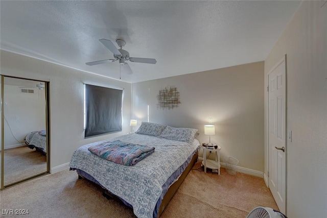 carpeted bedroom with a textured ceiling and ceiling fan