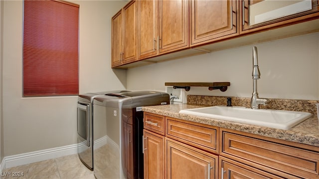 washroom with cabinets, separate washer and dryer, light tile patterned flooring, and sink