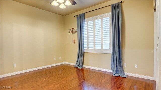 unfurnished room with a wealth of natural light, ceiling fan, and hardwood / wood-style flooring