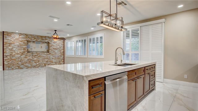 kitchen with dishwasher, sink, hanging light fixtures, light stone counters, and a center island with sink